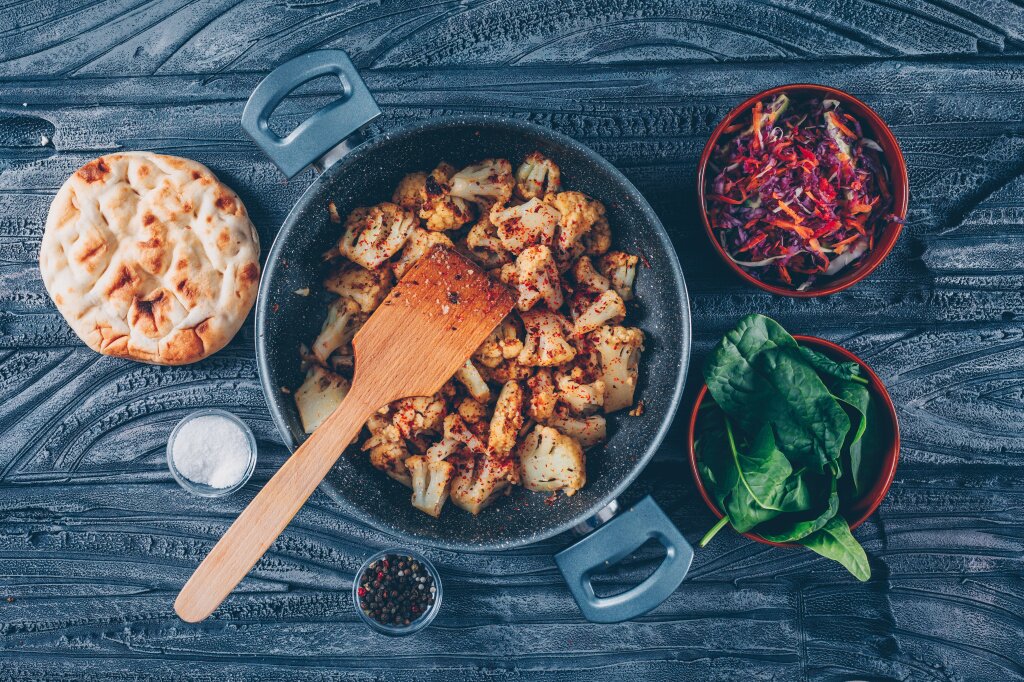 nekotoraa-zazarennaa-cvetnaa-kapusta-s-vegetable-salatom-zelenaa-v-bake-na-temnoi-derevannoi-predposylke-vzglad-sverhu.jpg