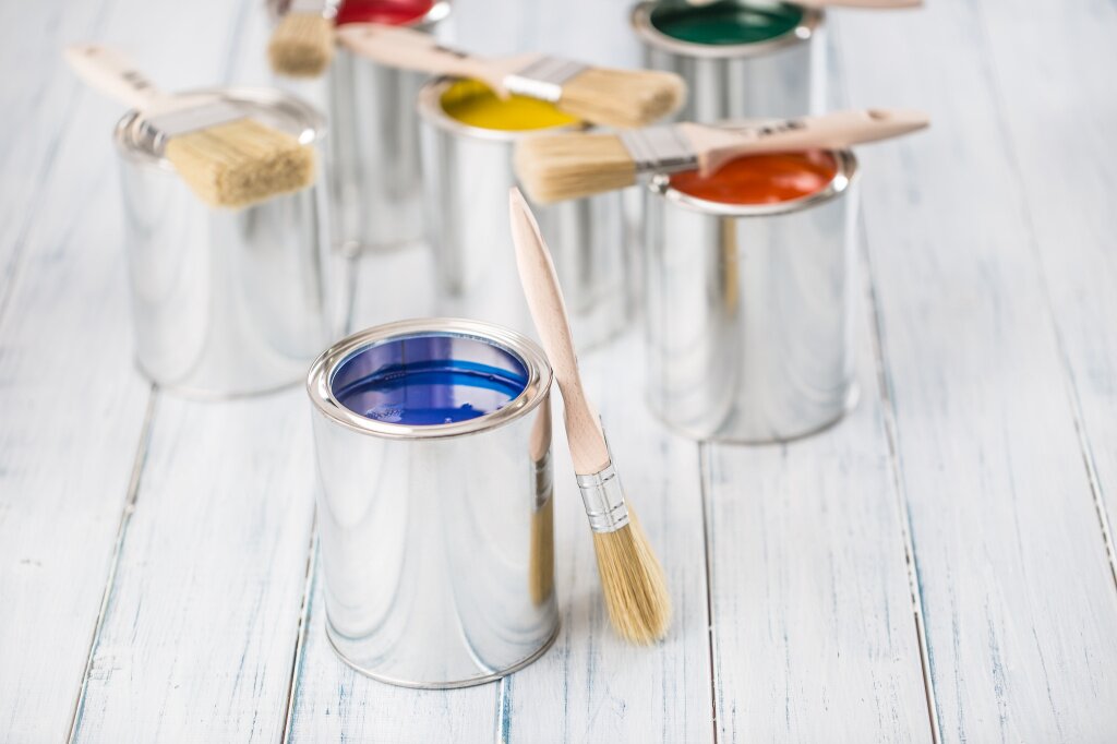 close-up-brushes-lying-multicolored-paint-cans.jpg