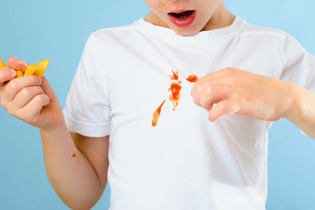 boy-s-hand-showing-dirty-sauce-stain-his-clothes-isolated-blue-background.jpg