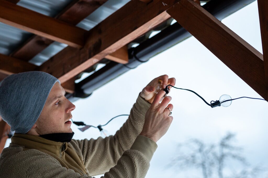 person-adjusting-led-string-lights-wooden-terrace-cold-season.jpg person-adjusting-led-string-lights-wooden-terrace-cold-season.jpg