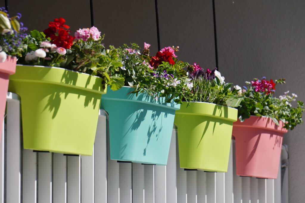 flowers-with-colorful-pots-white-fence.jpg