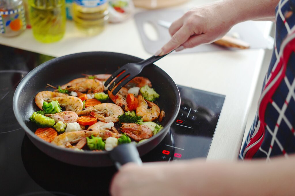 сковорода woman-staying-home-kitchen-cooking-shrimps-with-vegetables-pan-home-cooking-healthy-cooking-concept.jpg