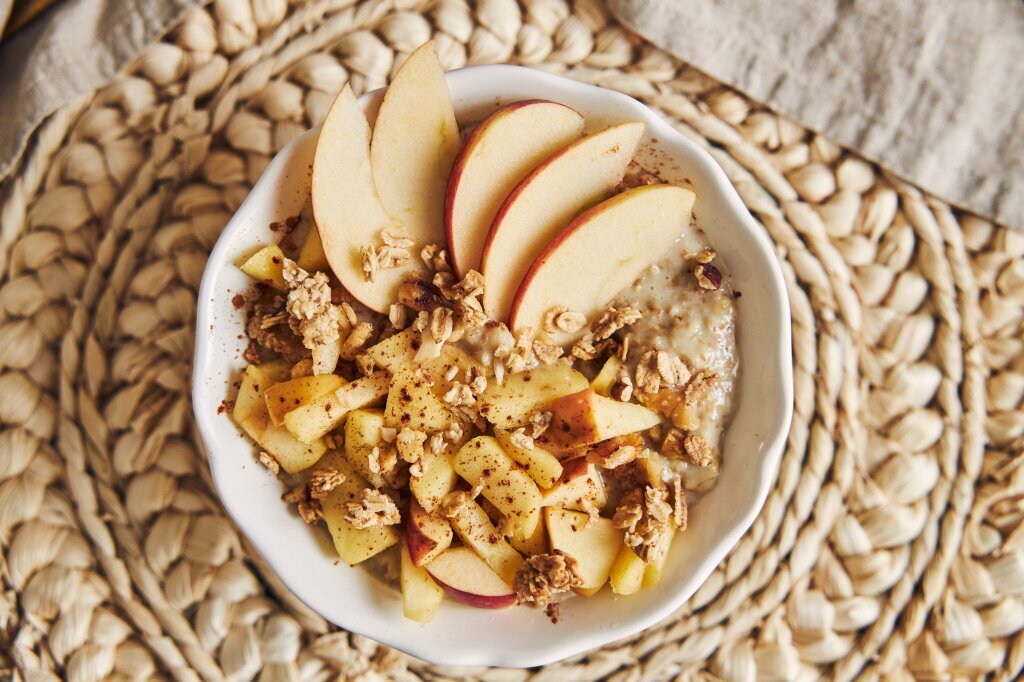 high-angle-shot-bowl-porridge-with-cereal-nuts-slices-apple-wooden-table.jpg