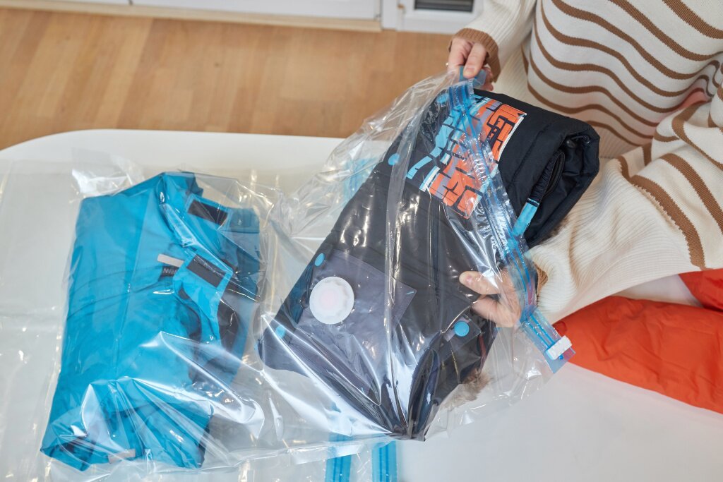 чехол для одежды girl-pumps-out-air-with-vacuum-cleaner-from-vacuum-bag-with-clothes-concept-storage-transportation-clothing-things-space-saving-seal-bag (1).jpg