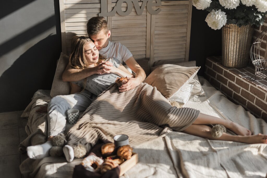 romantic-young-couple-holding-each-other-s-hand-with-breakfast-bed.jpg