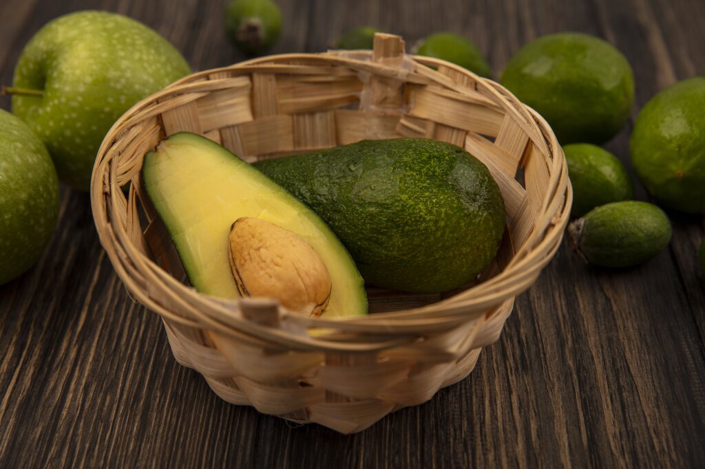 авокадо top-view-fresh-avocados-bucket-with-green-apples-limes-feijoas-isolated-wooden-wall.jpg