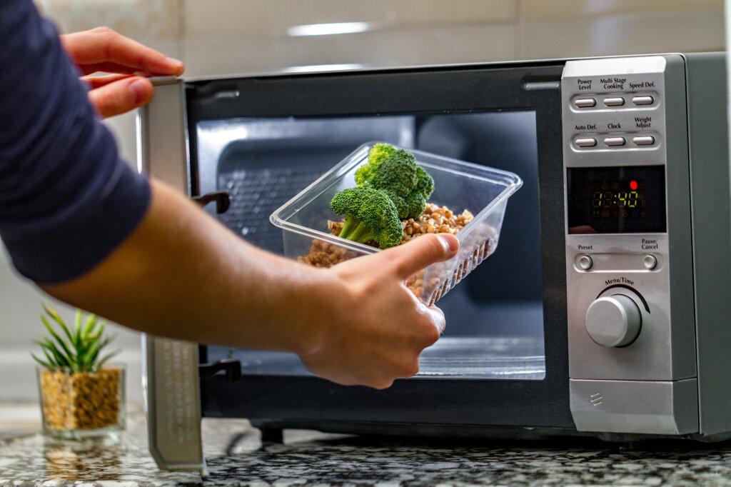 woman-s-hand-puts-plastic-container-with-broccoli-buckwheat-microwave.jpg