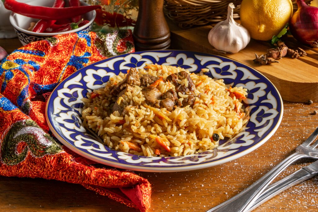 плов plov-s-baraninoi-tradicionnoe-vostocnoe-goracee-bludo-iz-otvarnogo-risa-baraniny-ovosei-i-specii-v-tarelke-s-nacional-nymi-uzbekskimi-ornamentami.jpg