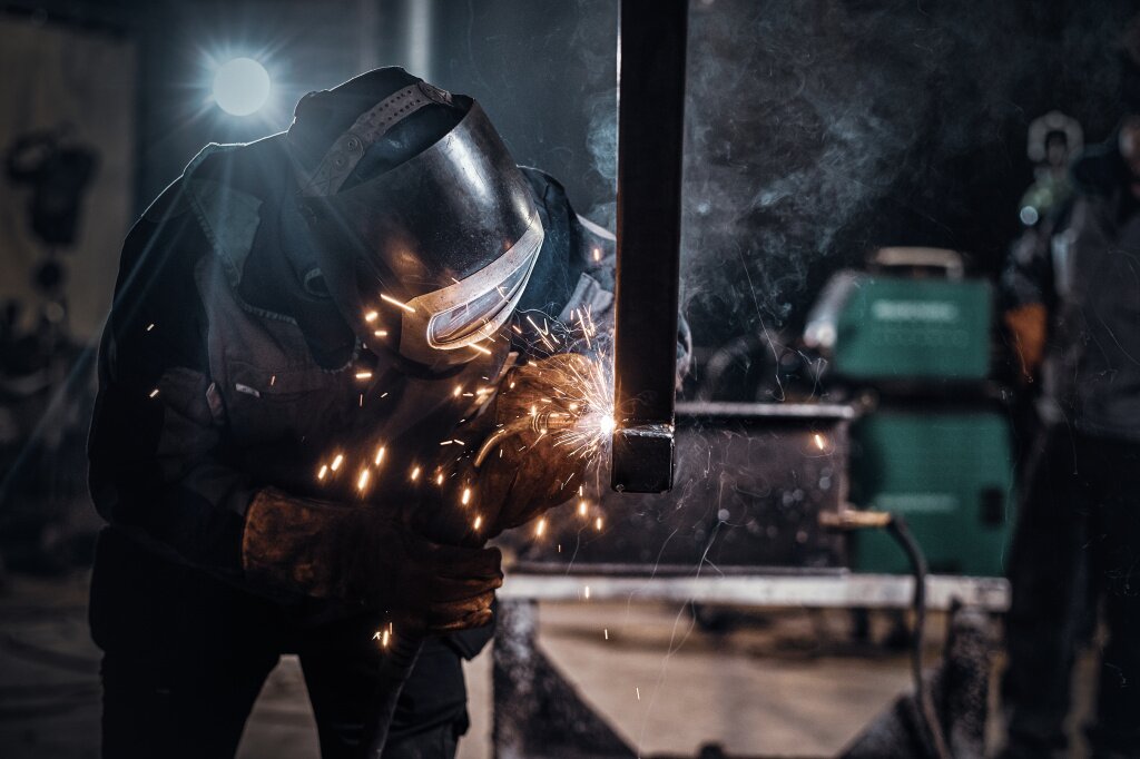 сварочный аппарат man-is-working-metal-factory-he-is-welding-piece-rail-using-special-tools.jpg