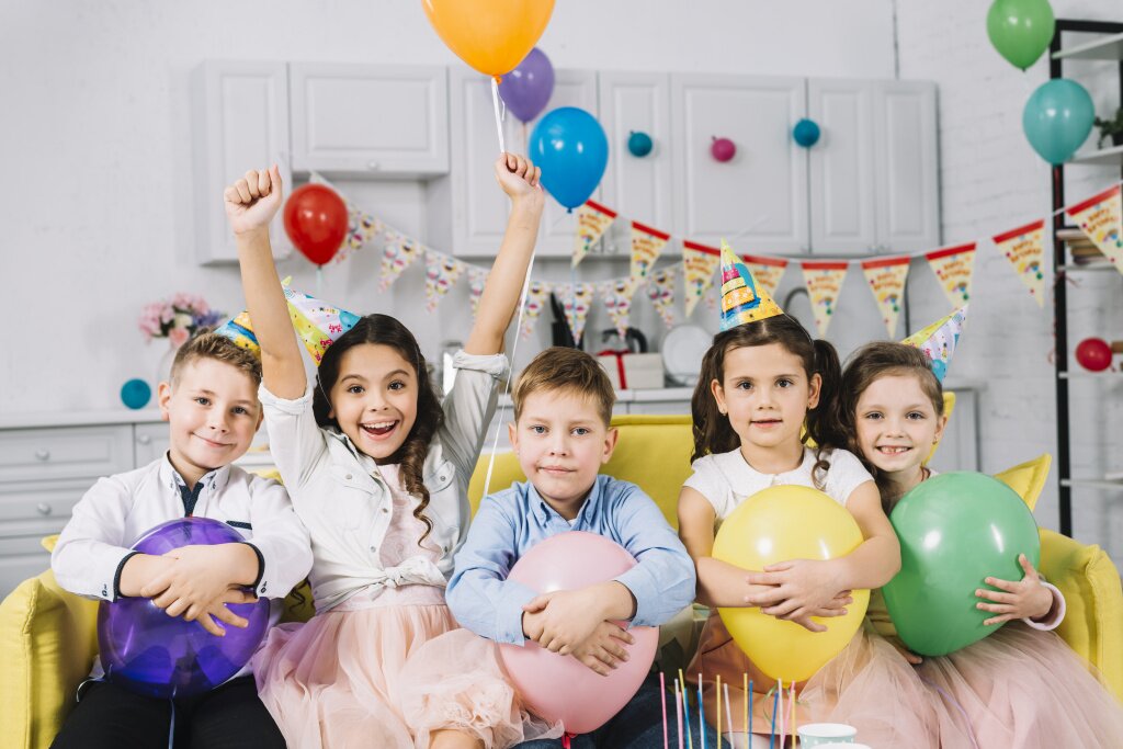 portrait-children-sitting-sofa-holding-balloons.jpg