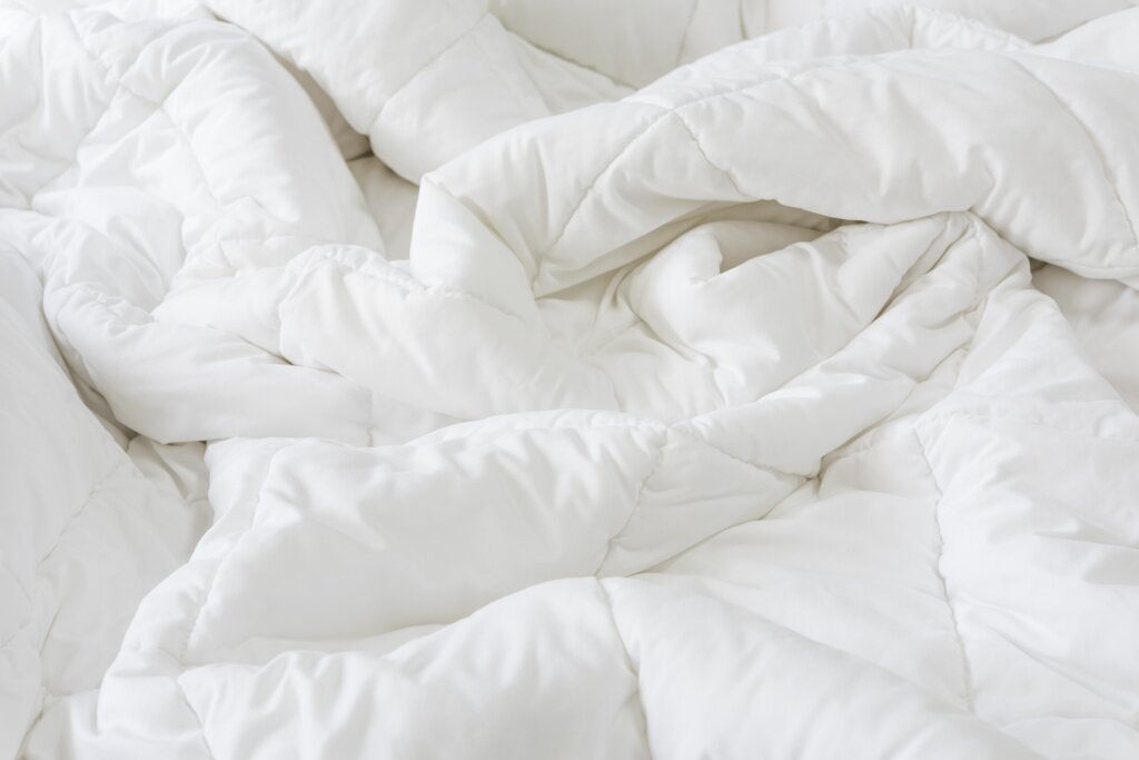 close-up-messy-white-sheet-pillows-bed-bedroom-interior.jpg