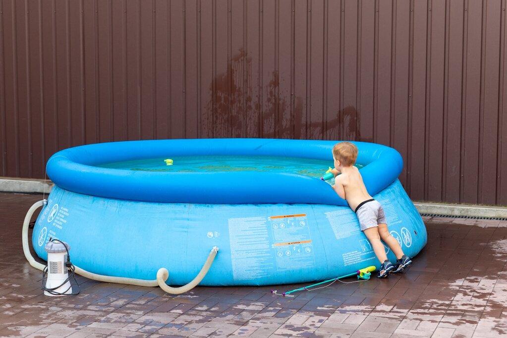 boy-standing-by-swimming-pool-against-wall.jpg