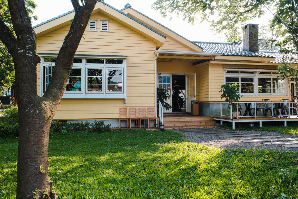 charming-yellow-house-with-wooden-windows-green-grassy-garden.jpg