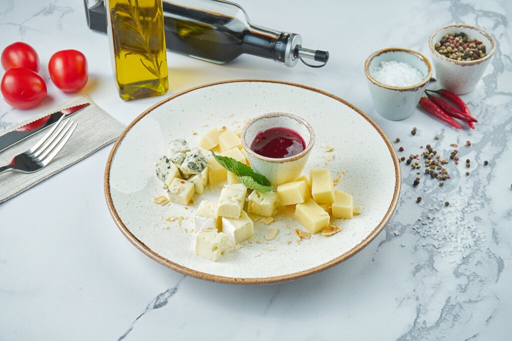 assorti-appetitnyh-syrov-dorblu-parmezan-magkie-syry-podaetsa-v-beloi-tarelke-s-vinogradom-i-medom.jpg