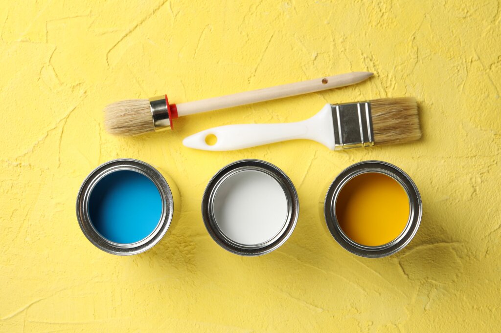 paint-cans-brushes-yellow-surface.jpg
