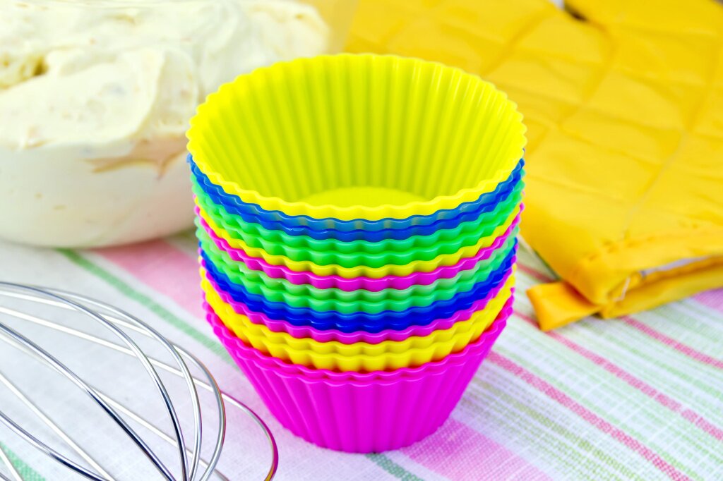 colorful-silicone-molds-cupcakes-mixer-yellow-cloth-potholder-dough-glass-bowl-linen-background.jpg